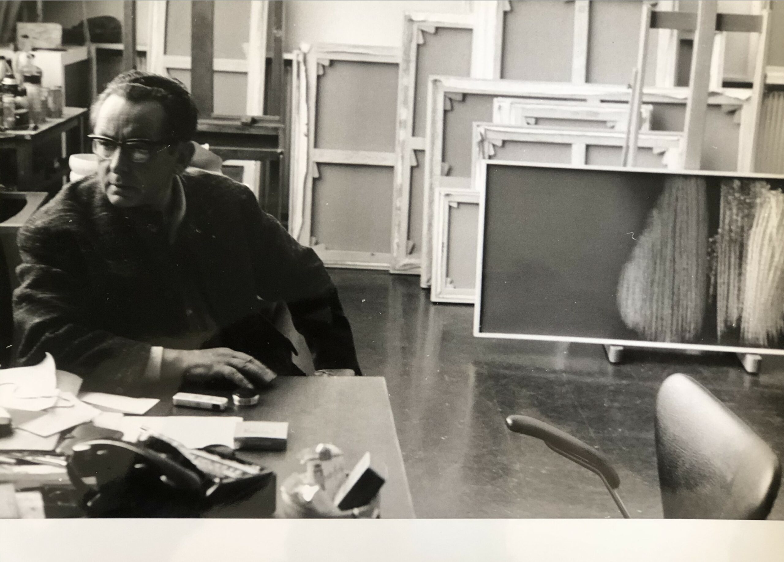 Hans HARTUNG - L'artiste assis dans son atelier, devant ses toiles.