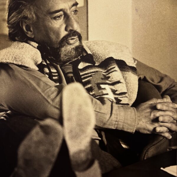 Romain GARY, en pleine discussion, les pieds sur son bureau.