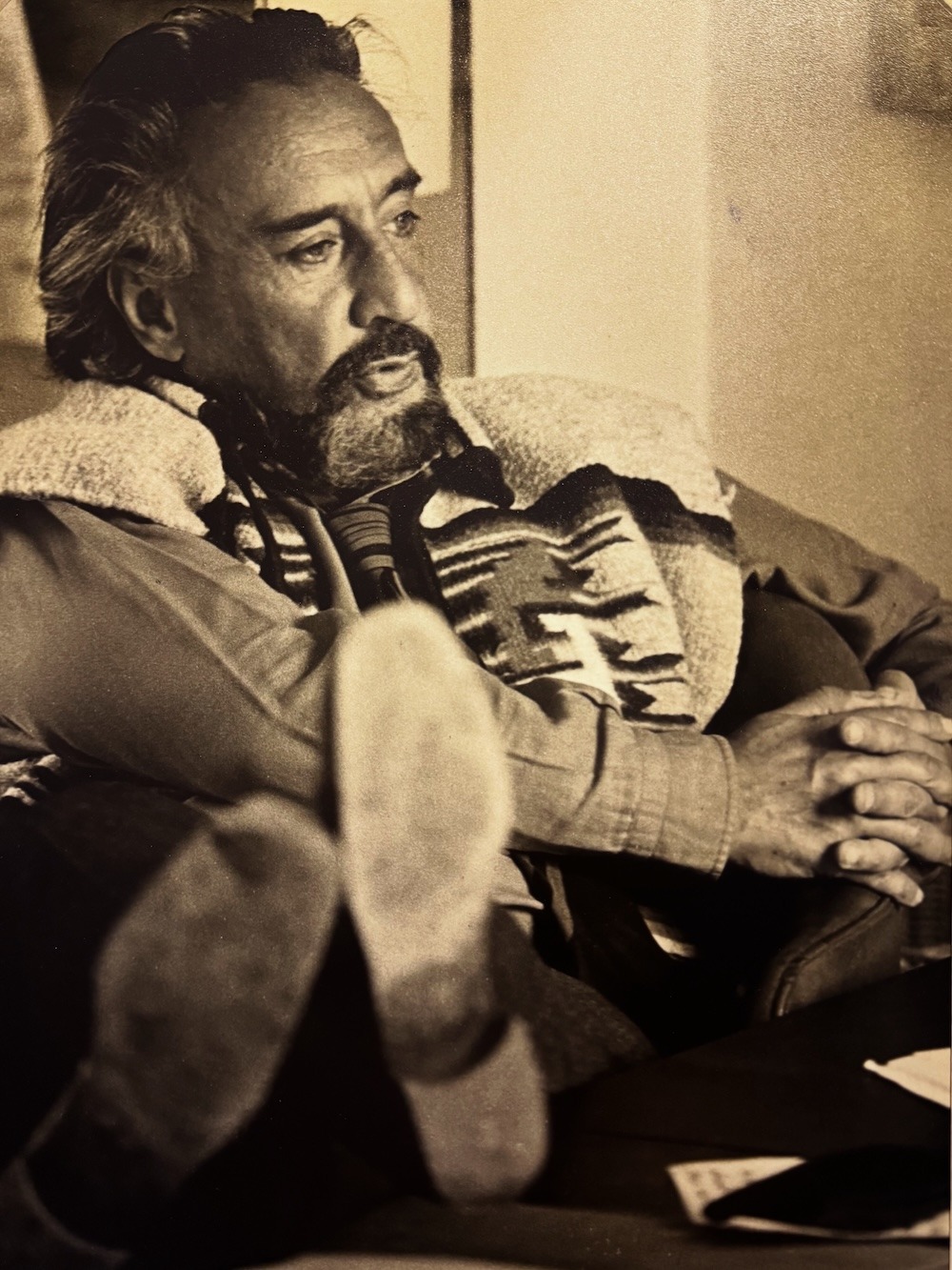 Romain Gary, absorto en una conversación, con los pies sobre el escritorio.